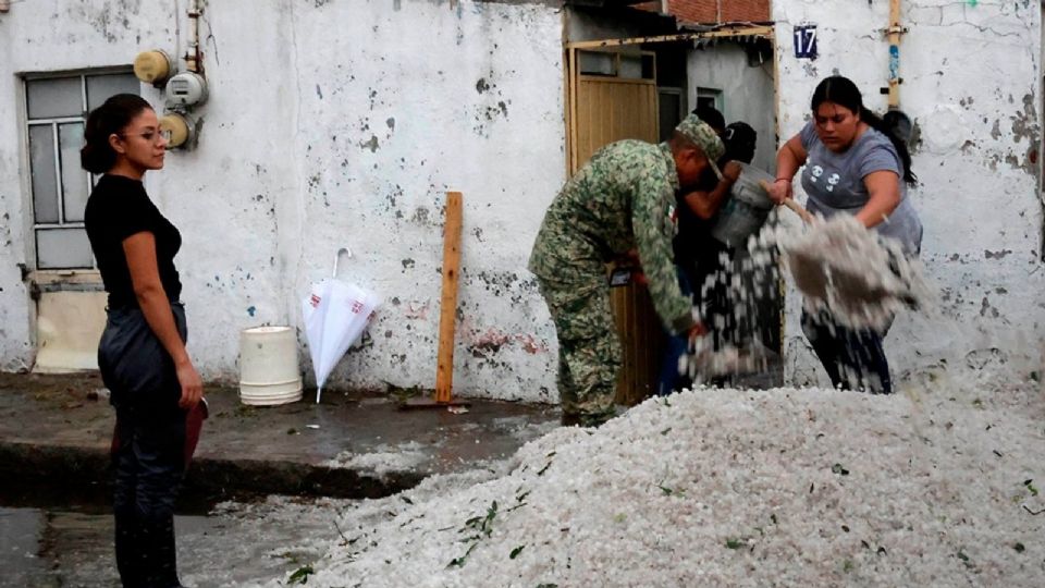 Vecinos retiran restos de granizo luego de las intensas lluvias.